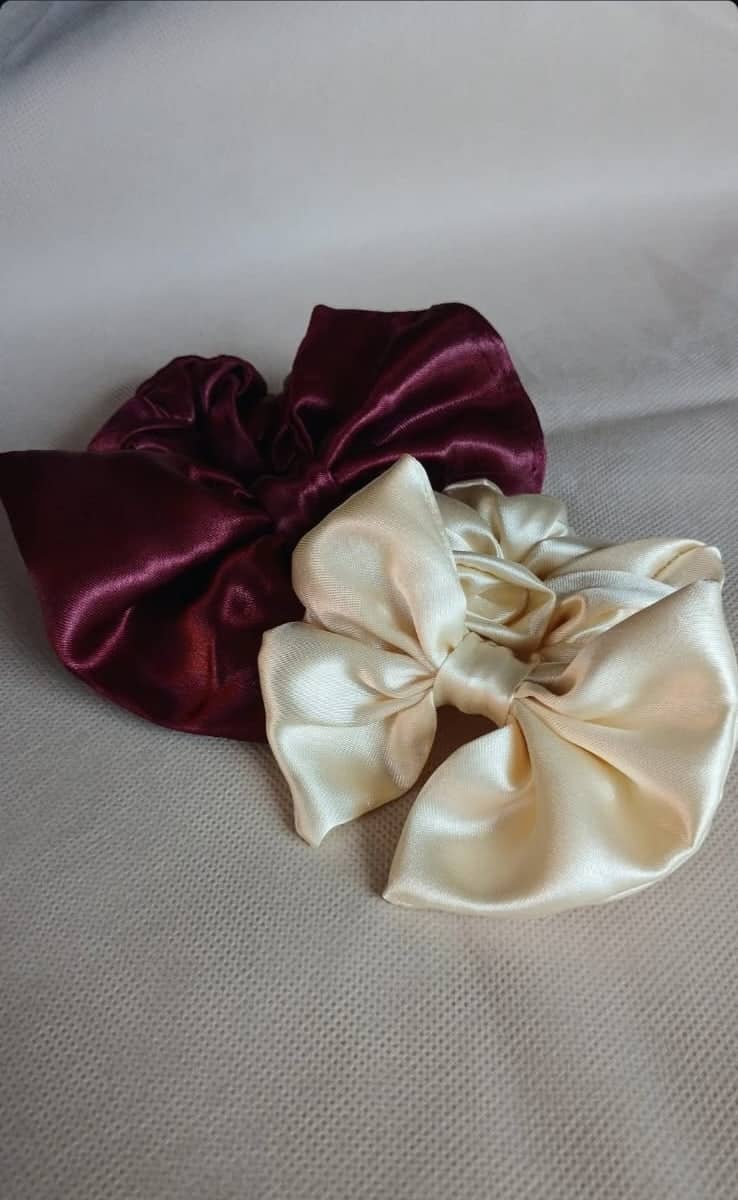 Detalle del satén en un scrunchie moño bordó y un moño crema de Ceferina